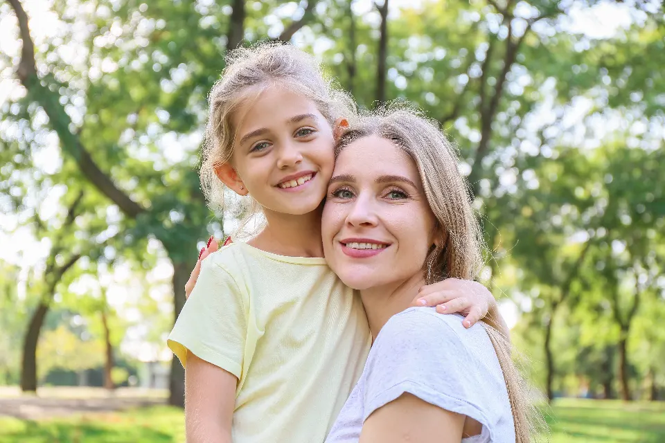 Mamá e hija abrazadas y sonriendo